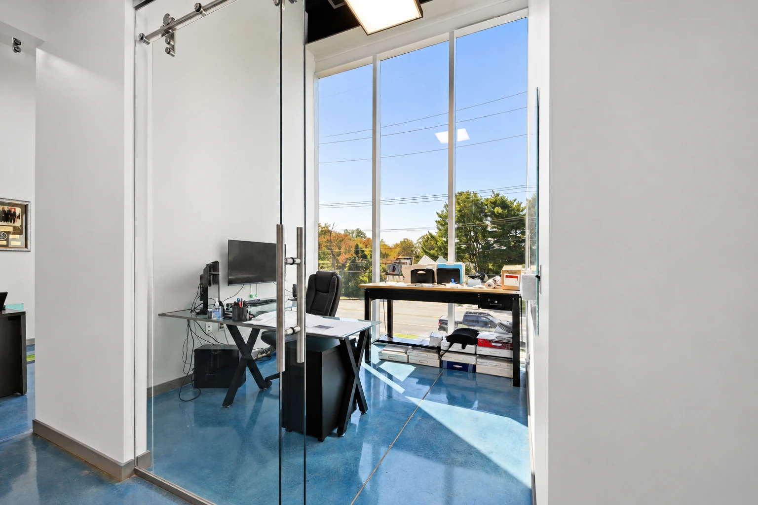 Office framed by glass partitions and tall windows