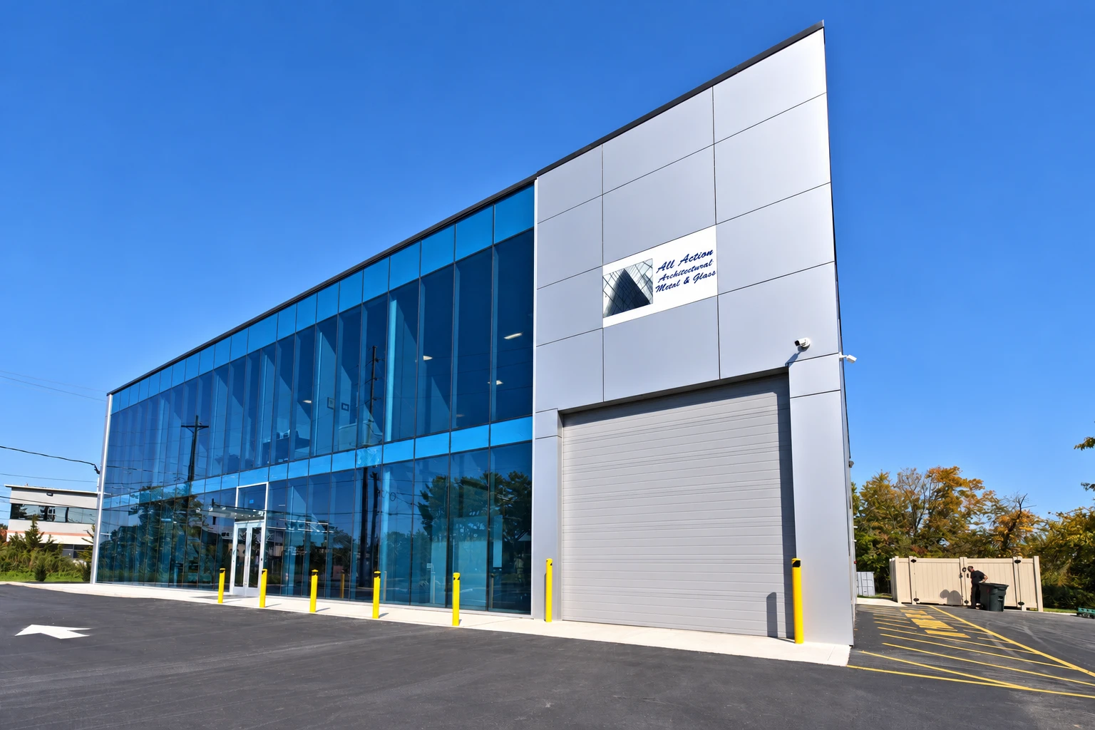 All Action Glass building with its blue glass facade and white exterior panels
